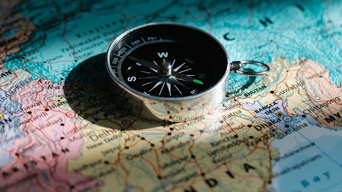 A compass resting on a paper map of India