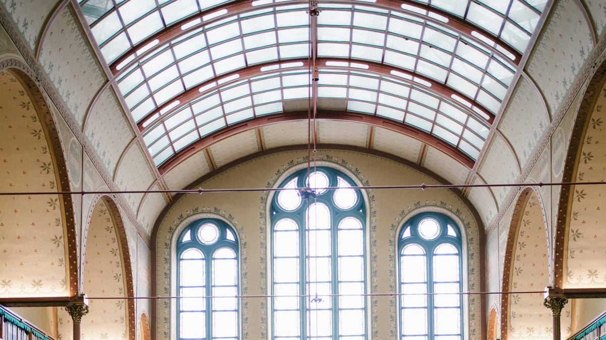 The arched windows and glass roof of an old library hall