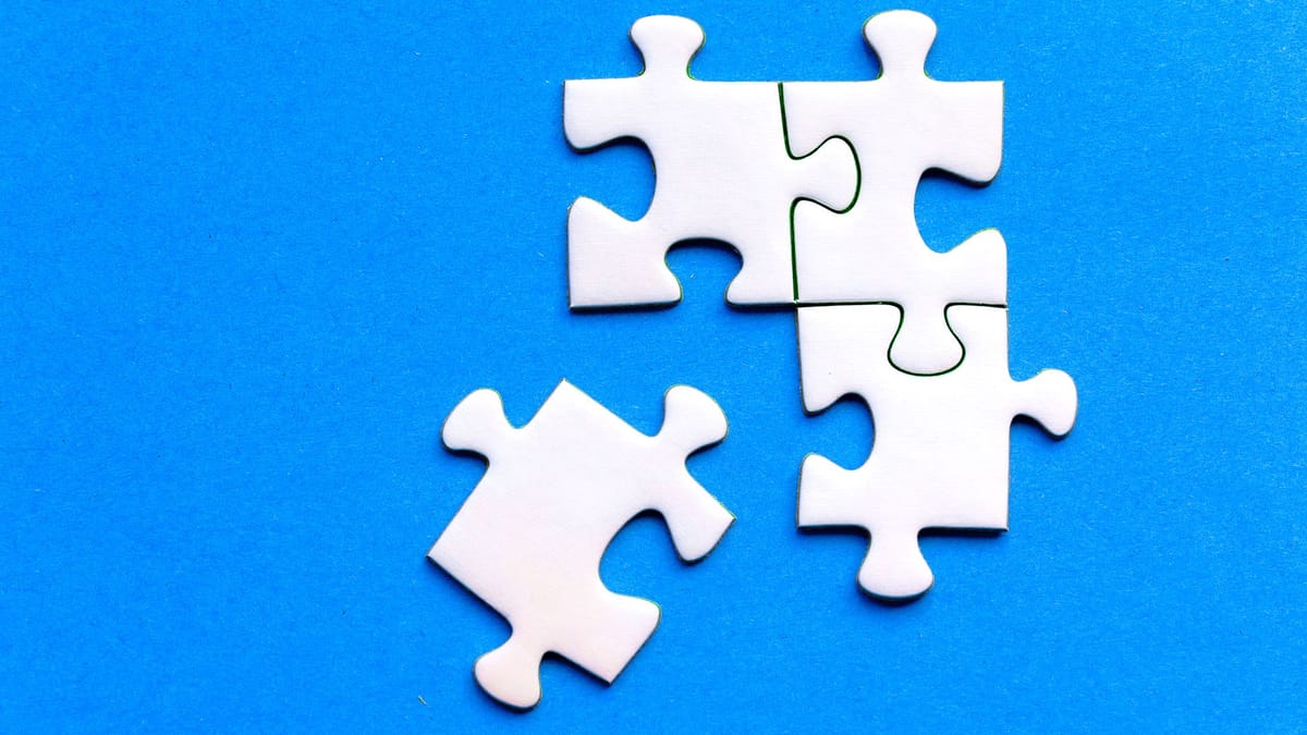 White jigsaw puzzle pieces fitting together on a blue surface