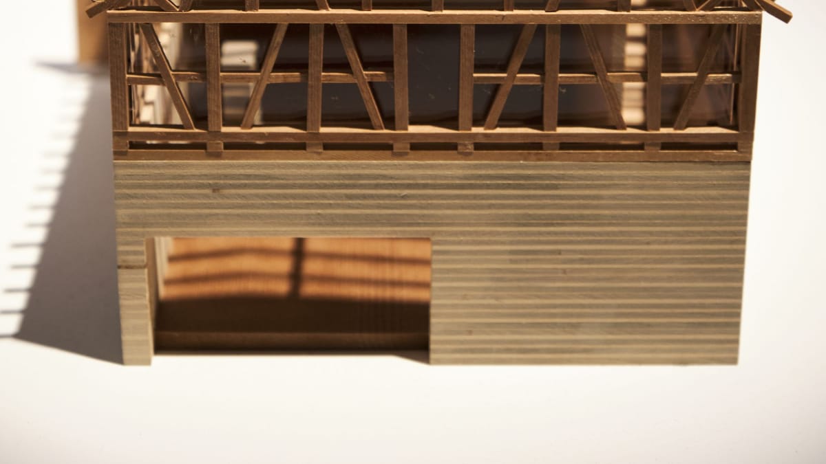 A wooden scale model of a small house